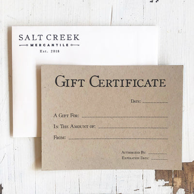 Paper gift certificate with white Salt Creek Mercantile envelope. 